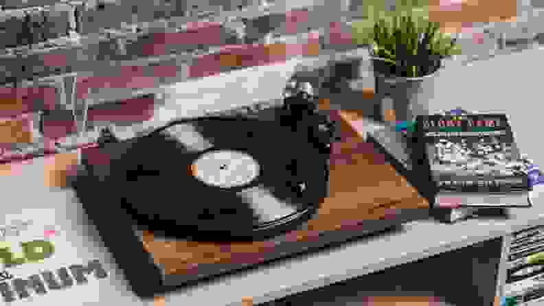 A wooden turntable plays a vinyl LP.