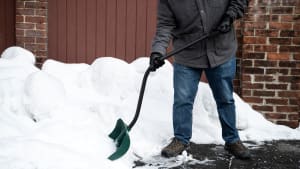 A person shoveling snow with an ergonomic snow shovel.