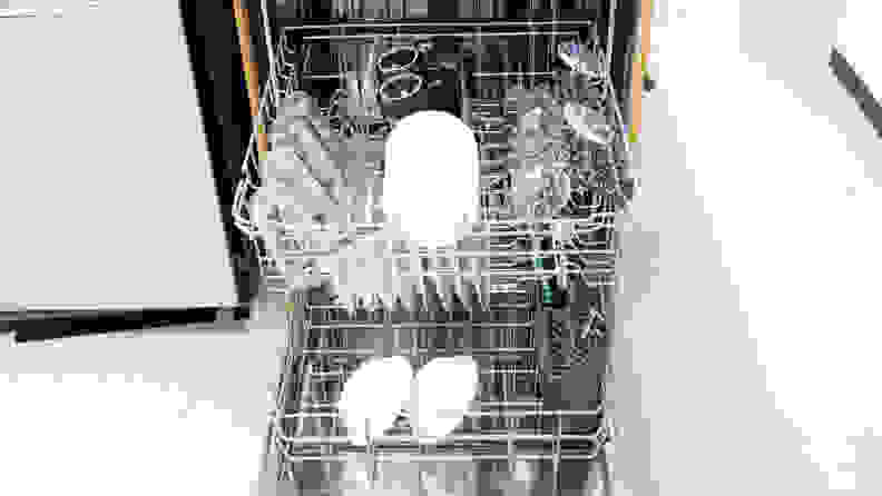 A close-up of the dishwasher with its door open and both of its racks pulled out. Each rack contains clean dishes.