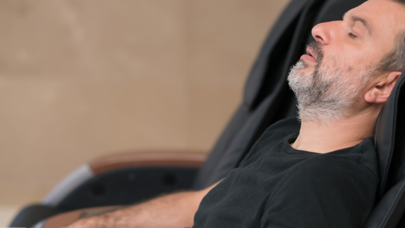 Man with eyes closed relaxing in massage chair