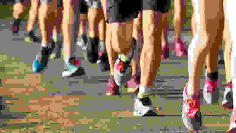 A group of runners running a race, a close-up image of their legs and feet.