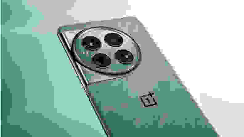 A teal-colored OnePlus 12 smartphone on a teal background.