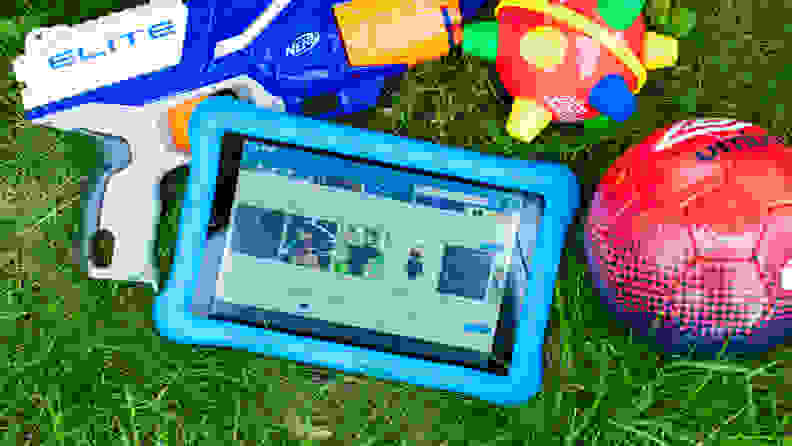 Amazon Fire Tablet for kids sits on the ground next to toys for kids