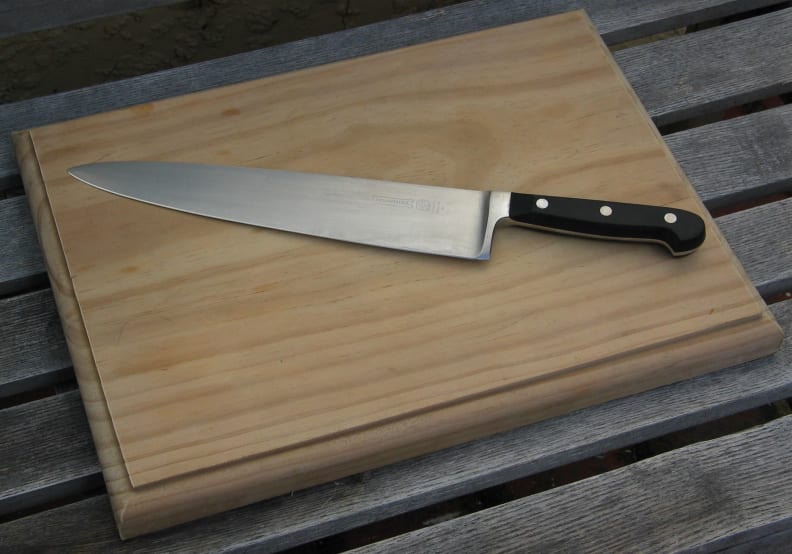 A cutting board with butcher's knife.