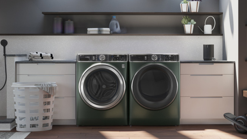 The jade green GE Profile PFW955SPWGN with matching dryer in a laundry room.