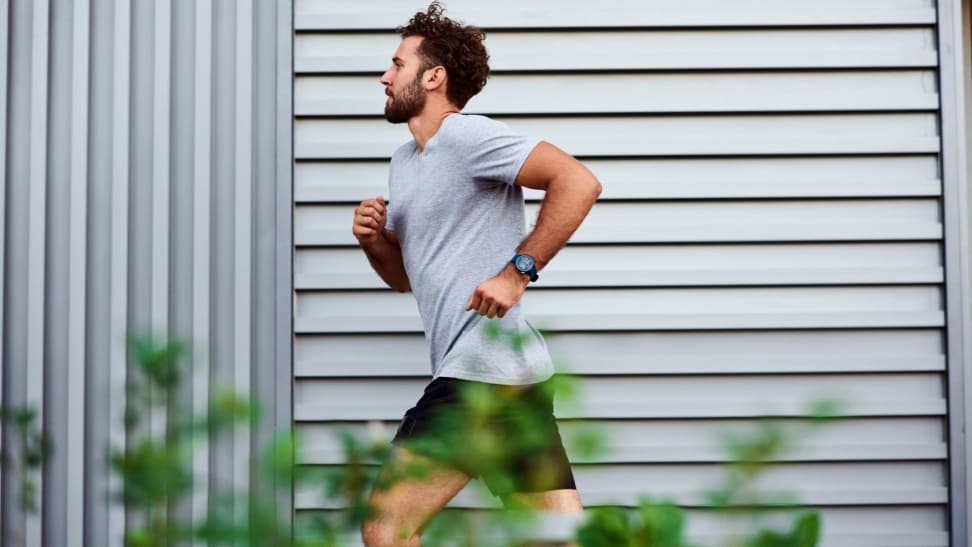 Man running on sidewalk in city