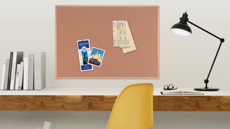 A cork board hangs above an office desk.