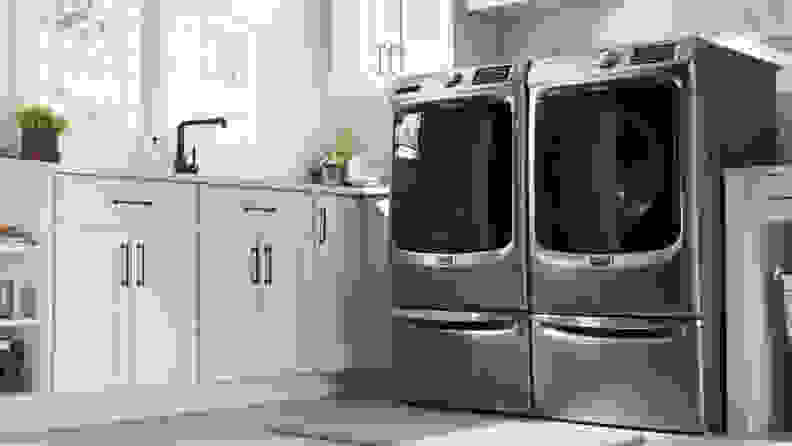 The Maytag MED6630HC beside a Maytag washer in a white kitchen.