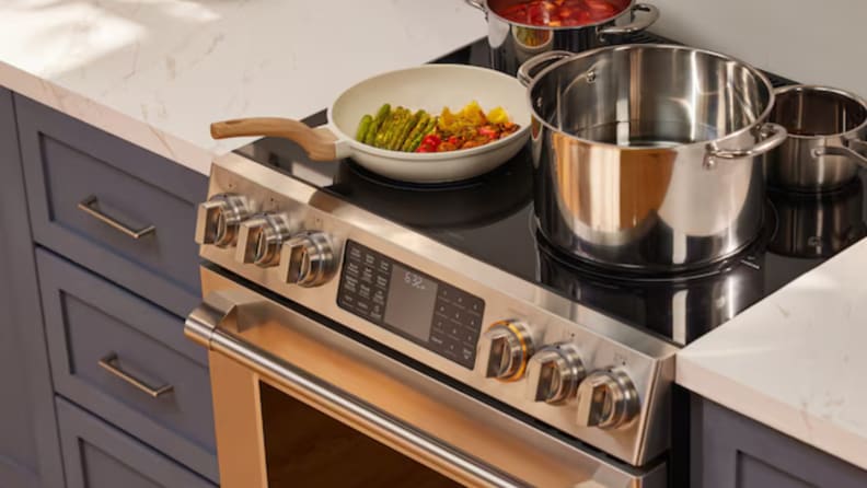 A view of the cooktop with pots and pans, and the controls on the Fotile RES30552 electric range.
