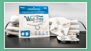 Wad-Free for Bed Sheets package next to folded bed sheets and the Wad-Free tool.