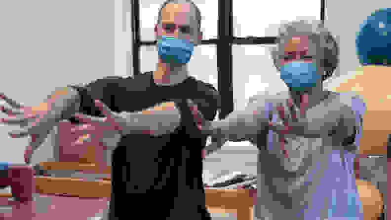 physical therapist and woman wearing protective mask