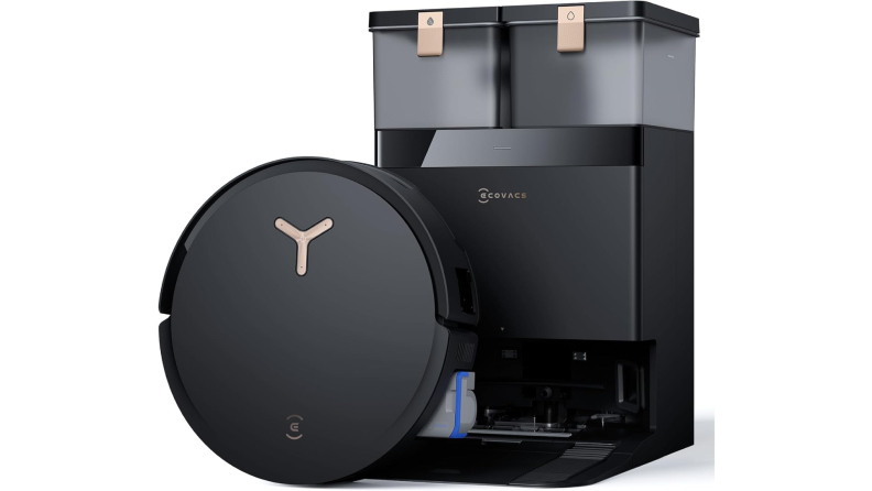 Black robot vacuum sits upright next to its charging base