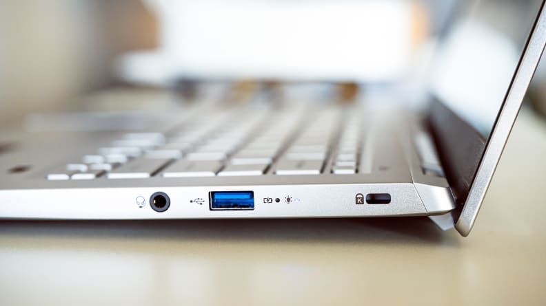 A close up of the connectivity ports the side of a silver laptop.
