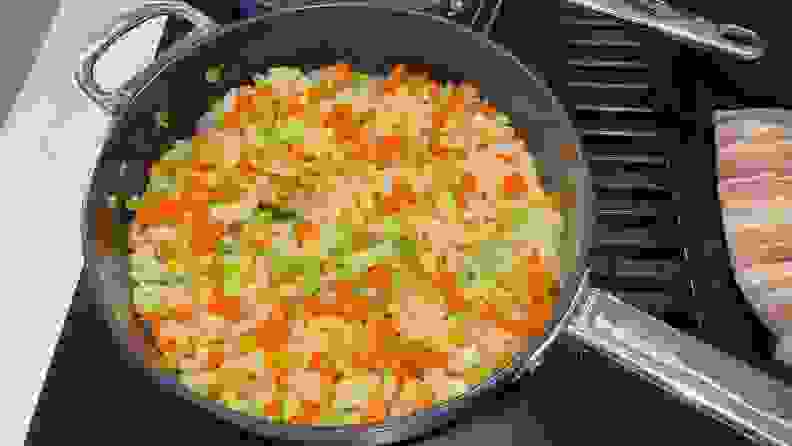Chopped vegetables being cooked inside a Joesph Joseph pan.