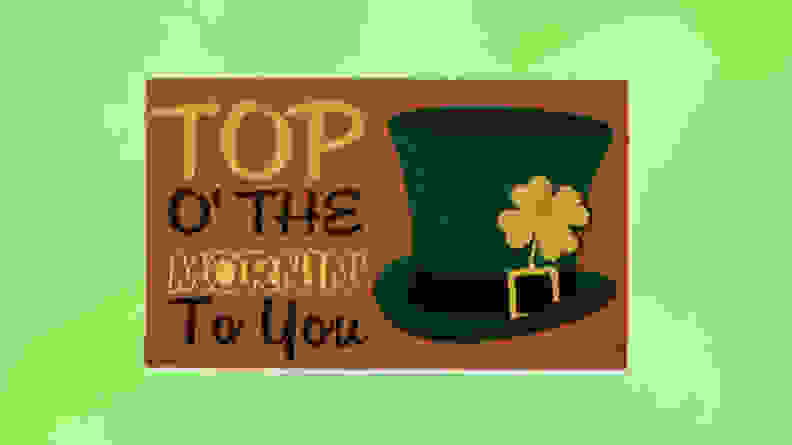 A brown doormat with Top Of The Mornin' To You with a green tophat in front of a green background.