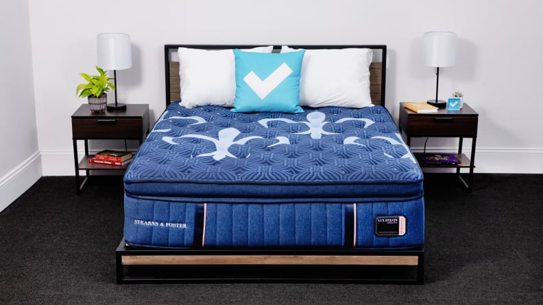 The Stearns & Foster mattress appears in a bedroom with bedside tables on either side.