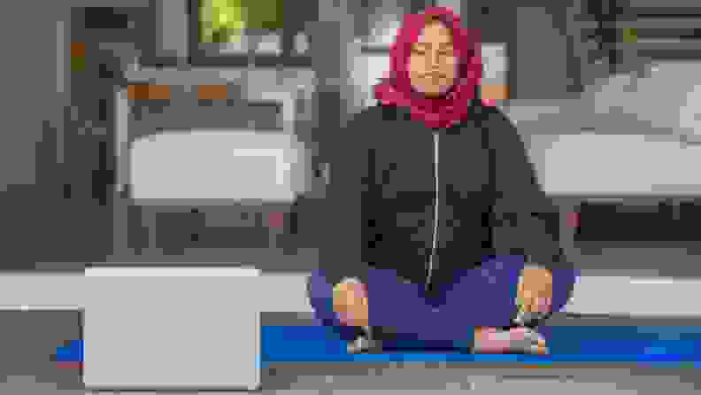 a person sits on the floor with their computer meditating