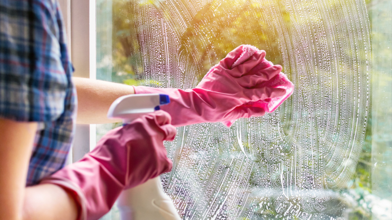 A person cleaning a window pane,