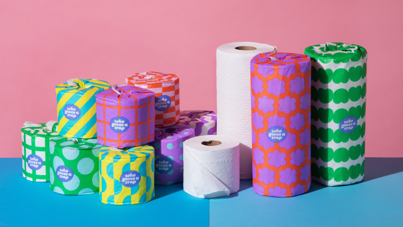 toilet paper and paper towels in colorful wrapping paper on pink and blue background