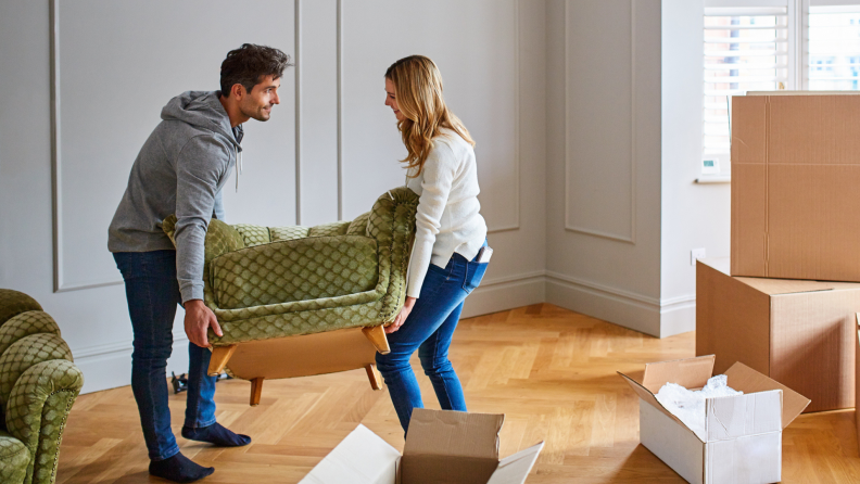 A couple moves furniture into their new home.