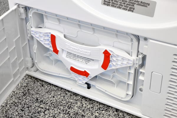 Bright red arrows remind users how to release the Blomberg DHP24412W's secondary lint trap.
