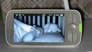Black and white video footage of sleeping child on the screen of the Infant Optics DXR-8 Pro baby monitor.