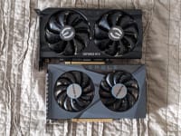 The Nvidia GeForce RTX 3050 and the AMD Radeon RX 6500 XT laying flat on a sheet.