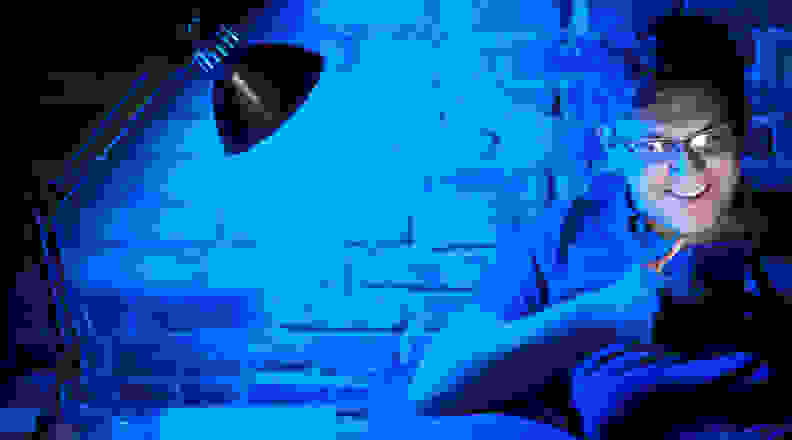 Man sitting in blue light on smartphone