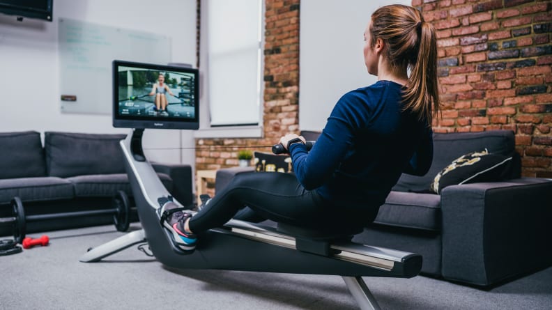 woman exercising on hydrow rowing machine.