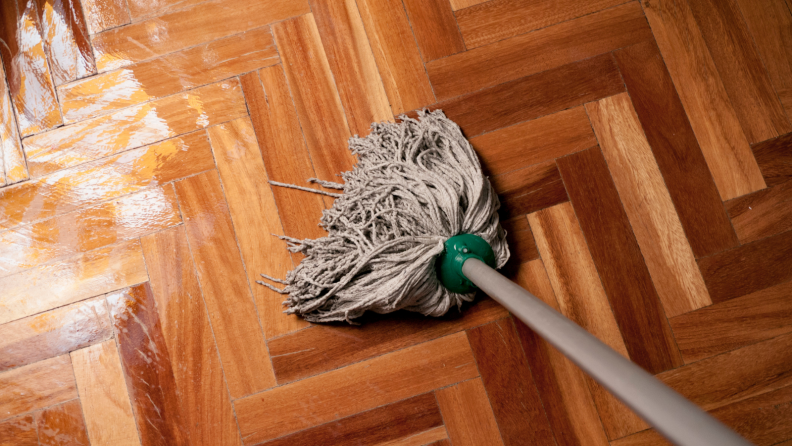 A wet mop on a dirty floor.