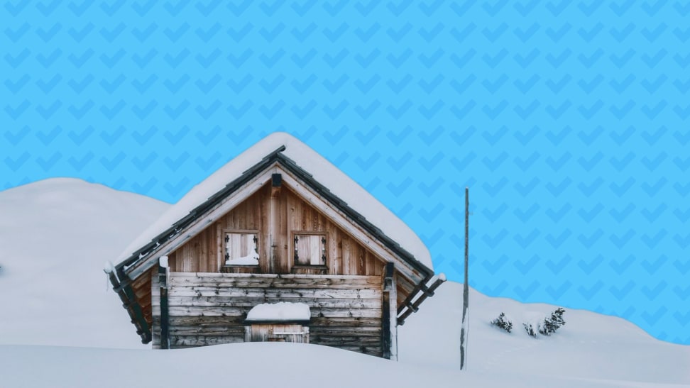 A snowed-in cabin in a winter landscape in front of a blue-checkmark Reviewed background.