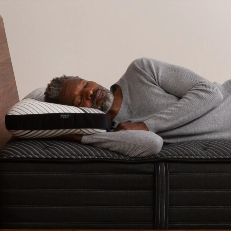 A man sleeping on a Beautyrest Black Luxury Foam Pillow.