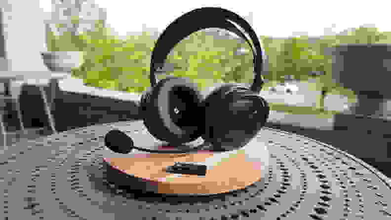 A pair of gaming headphones with a mic arm on a wooden platform