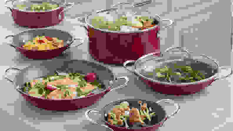Red cookware on countertop with food in it