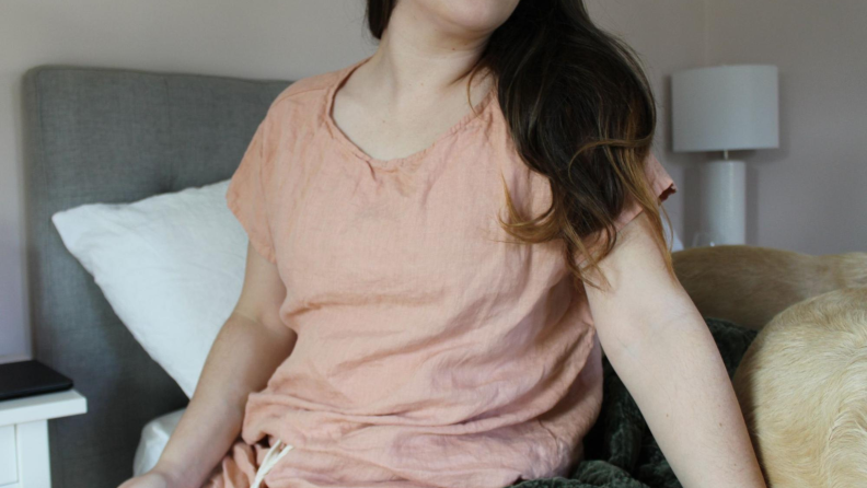 Woman sitting on the edge of the bed wearing MagicLinen pajamas