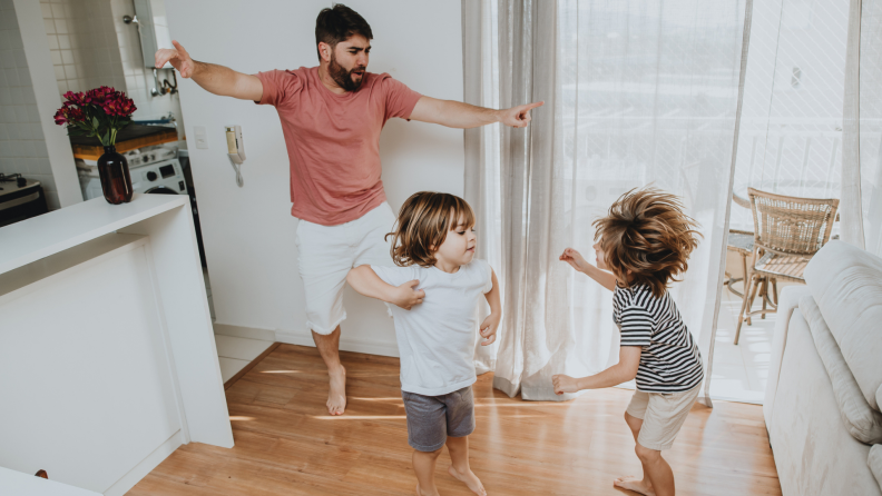 Father dancing with two young children.