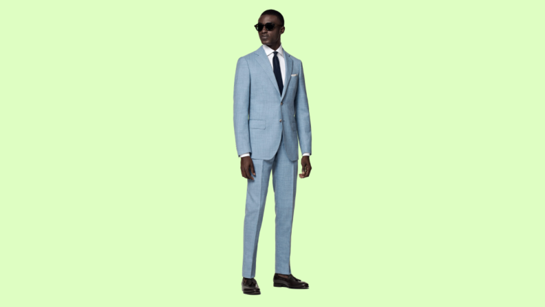 A light blue suit against a green background.