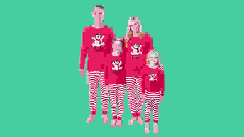 A family wearing the INTIMO Frosty the Snowman tight fit family pajama set on a green background.
