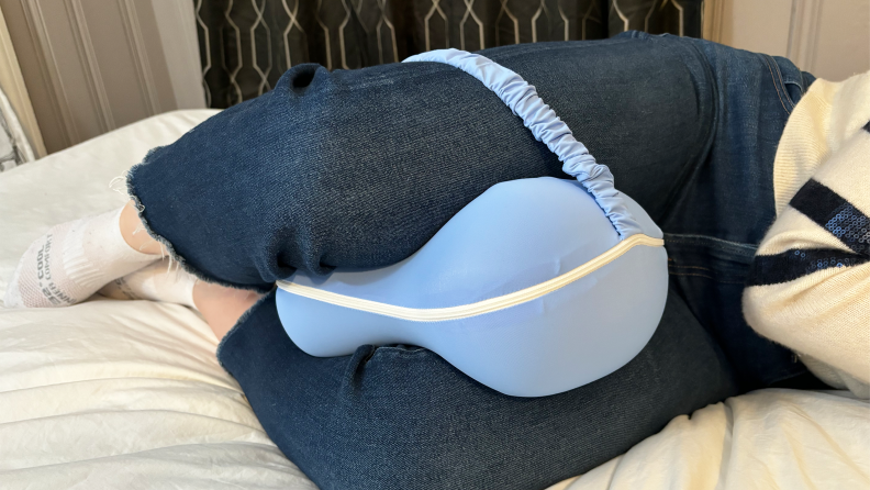 A tester places the Omloon Leg Elevation Pillow between her thighs
