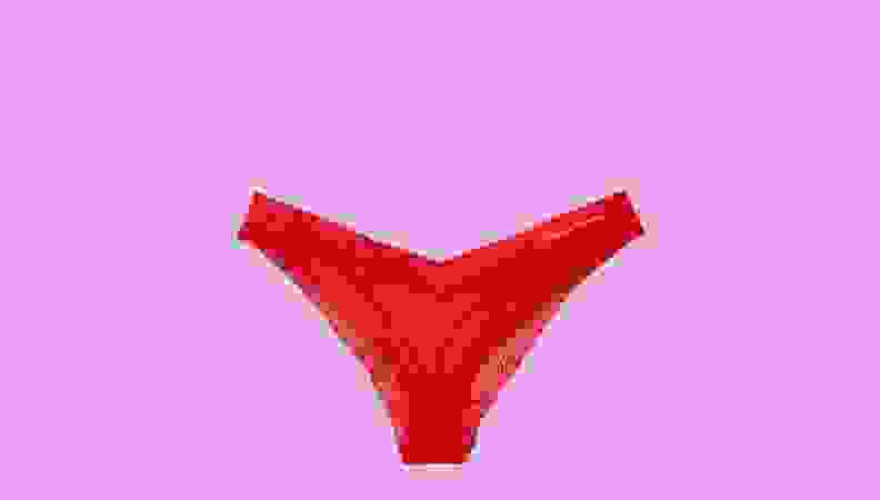 A pair of red underwear against a hot pink background.