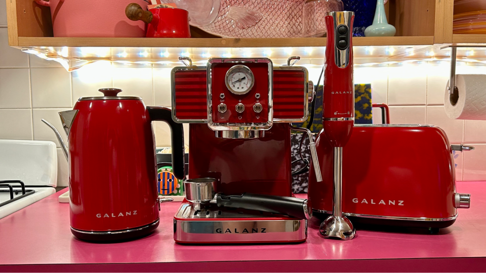 Multiple Galanz countertop appliances, such as, a hand blender, an espresso machine, a toaster, and tea kettle in the color red.
