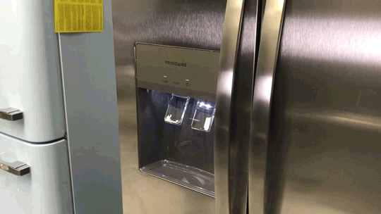 Moving gif of person using glass to dispense ice on the Frigidaire FRSS2623AS.