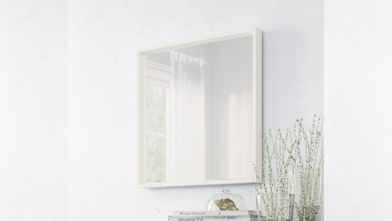 A square mirror hung on a wall.