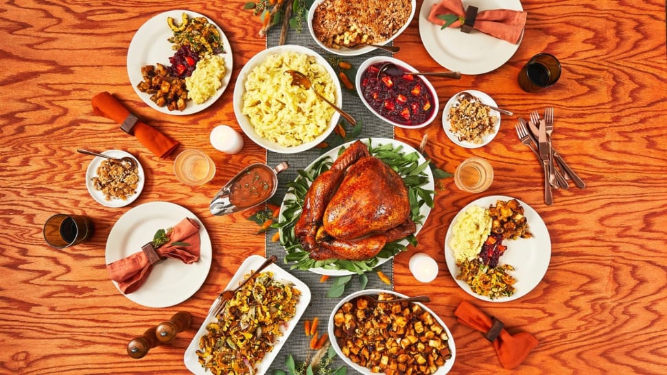 A top-down photo of a Thanksgiving feast with turkey and multiple side dishes.