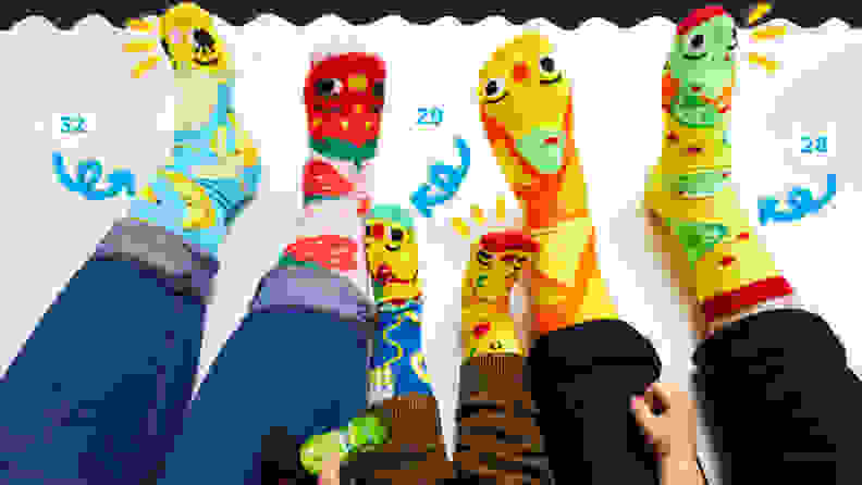 Three pairs of feet (2 adults and one kid in the middle) wearing colorful monster socks