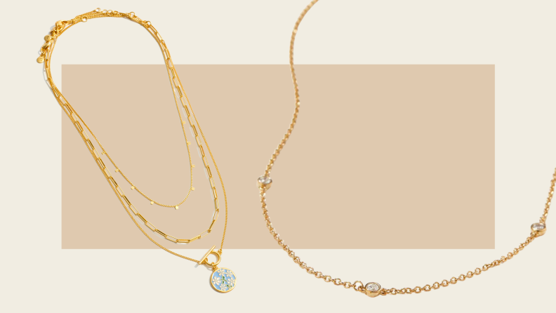 Two gold necklaces against an abstract tan-colored background.