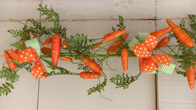 A green garland with orange carrots hanging from it