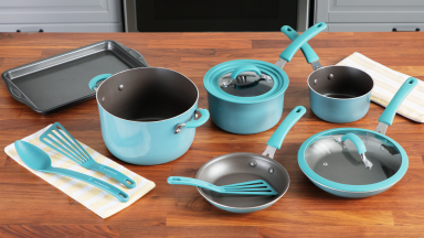 A set of nonstick cookware and utensils on a wooden surface