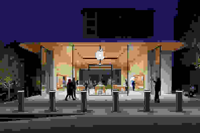 An Apple store open and lit in the dark.