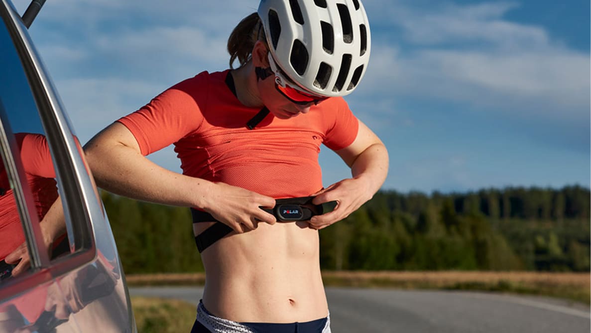 A woman attaching the Polar H10 heart rate monitor before a bike ride.